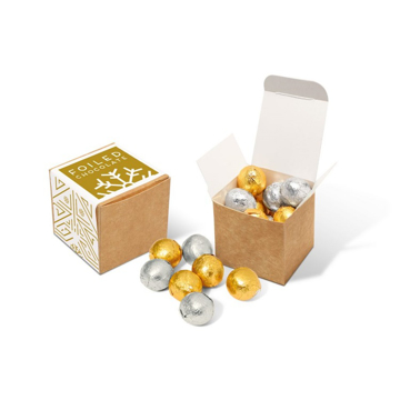 a brown cube filled with silver and gold chocolate balls with promotional festive label.